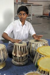 Student playing tabla