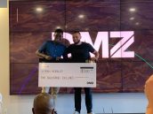 Raphael Mwachiti (far left) with Abdullah Snobar (far right), Executive Director of the DMZ, after winning the DMZ Sandbox competition.