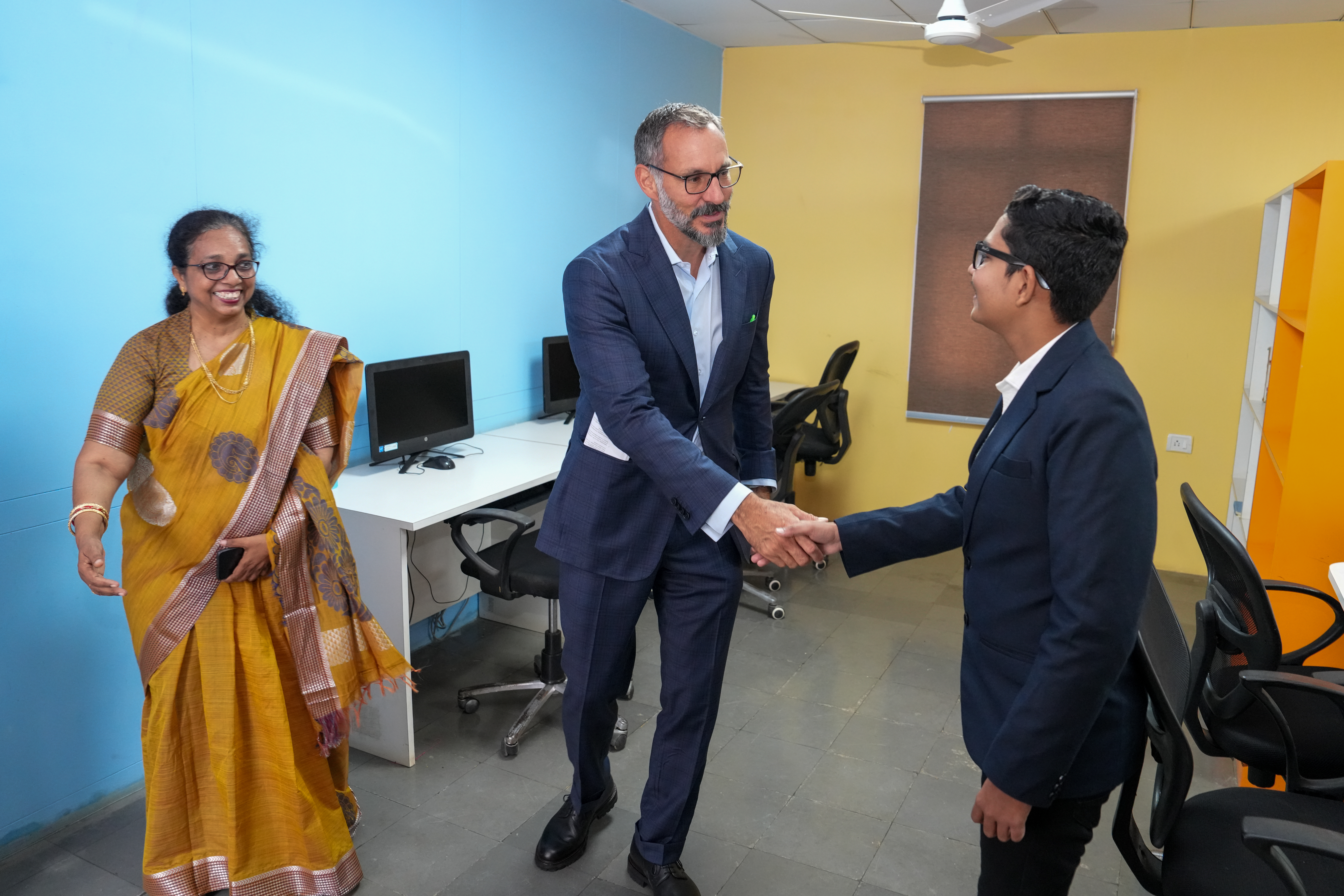 Prince Rahim Aga Khan shaking hands with a student from the Aga Khan Hostel, Hyderabad with a teacher