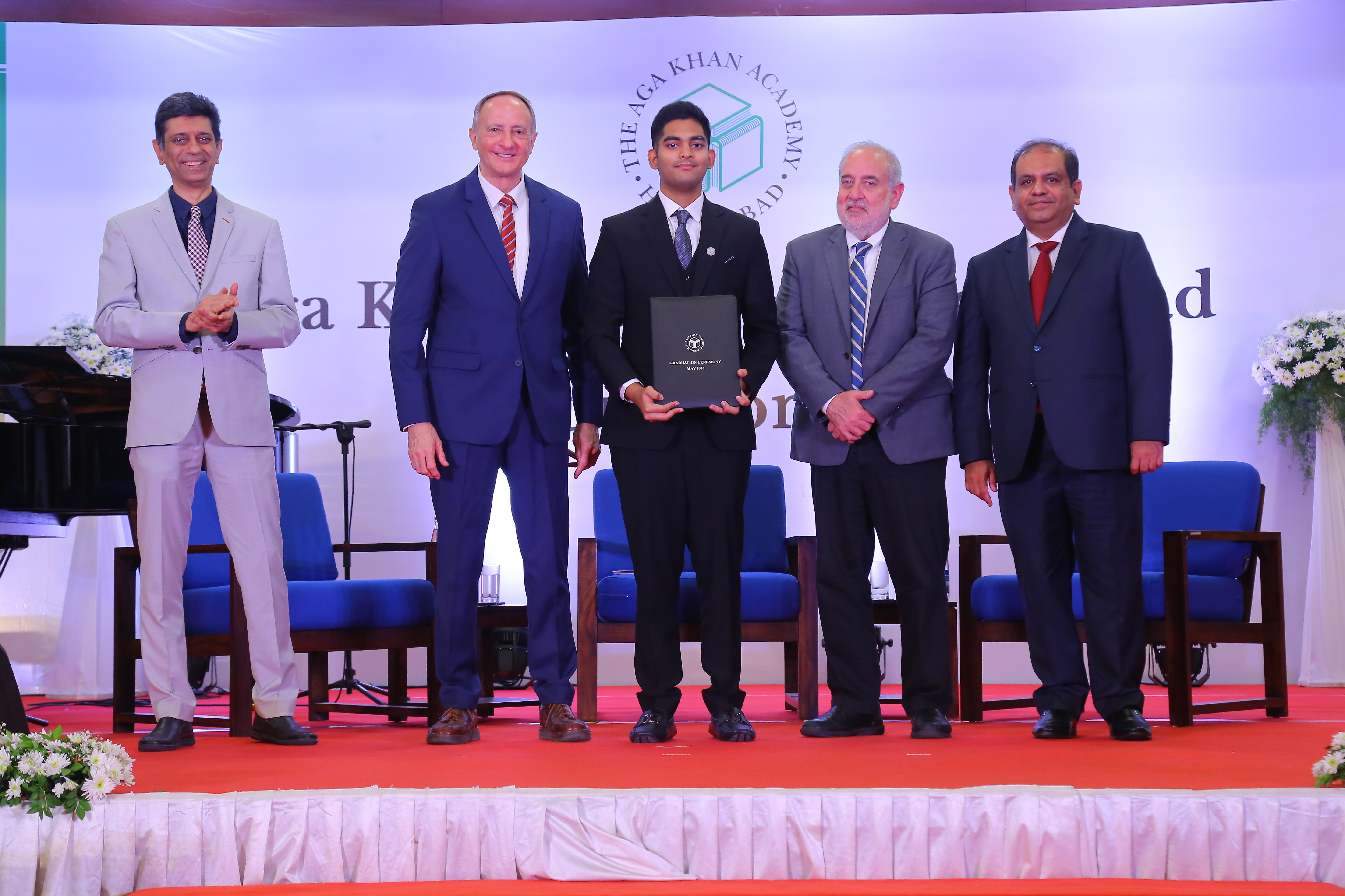 Graduate receiving a graduation folder.