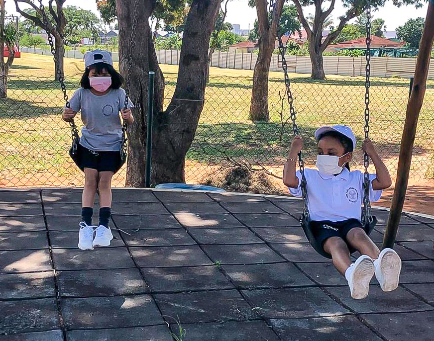 Early Years students playing on the swings