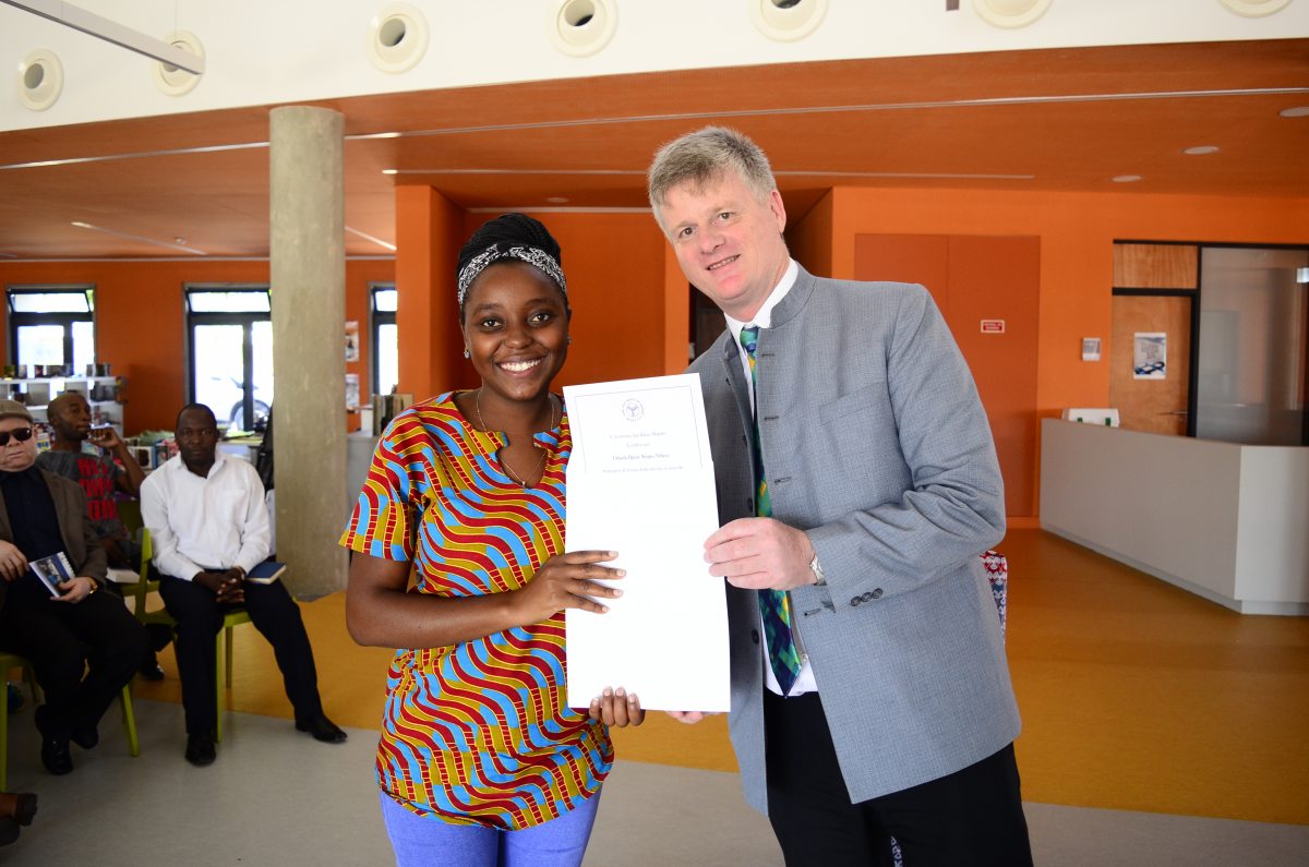 A teacher with her training completion certificate and the AKA Maputo Head of Academy