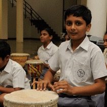 Student playing tabla